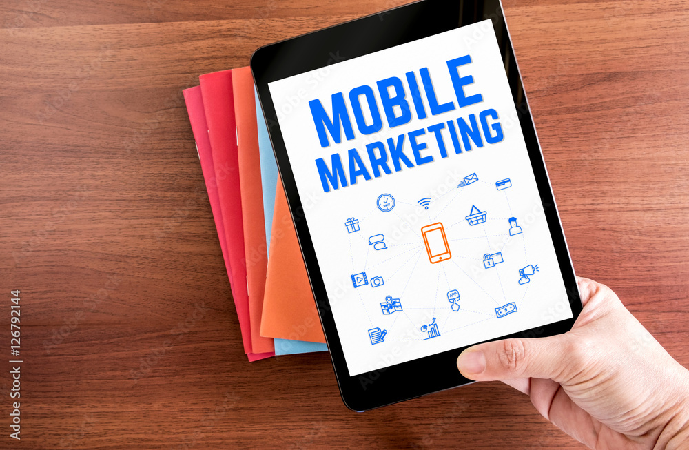 Poster top view of hand holding tablet with mobile marketing word with