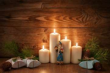 christmas gift boxes spruce twigs candles Santa cones on wooden background