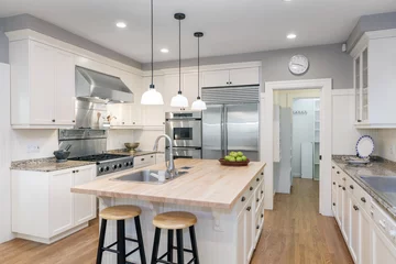 Foto op Plexiglas Amazing Luxury Kitchen Interior in white with wooden floor and kitchen island. © coralimages