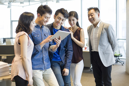 Businessman showing digital tablet to colleagues