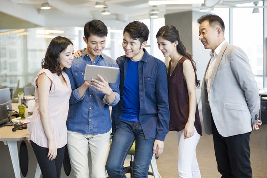 Businessman showing digital tablet to colleagues