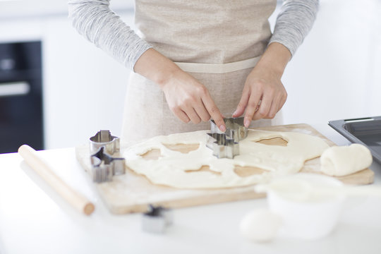 Young woman making cookies in kitchen