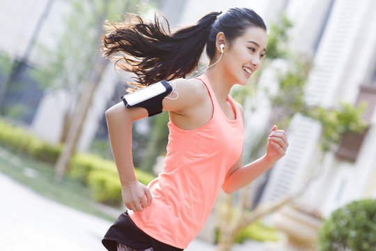 Young woman jogging and listening to music