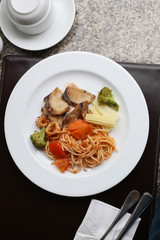 Fried Spaghetti and grilled fish on white dish.