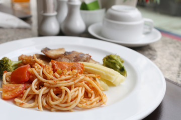 Fried Spaghetti and grilled fish on white dish.