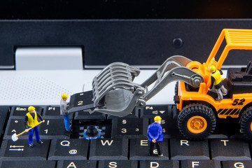 Tiny toys team of engineers repairing keyboard computer laptop.C