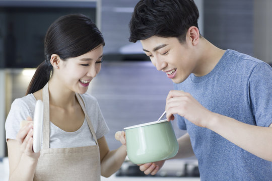 Happy young couple cooking in kitchen
