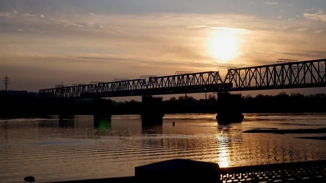 leaving train across the river at sunset