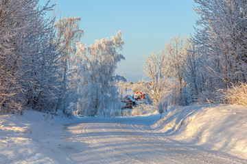 Winter road with a red house in the countryside