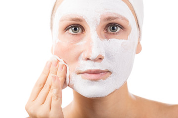 A young girl makes a face mask.