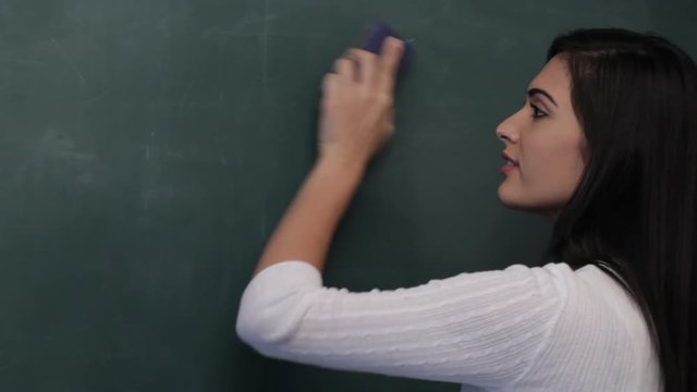 MS Woman erasing mathematical formula from blackboard