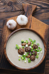 Top view of champignon soup served in a wooden bowl, studio shot