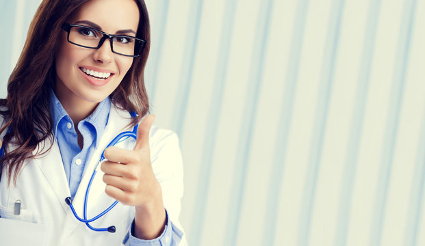 Young doctor showing thumbs up gesture, with copyspace