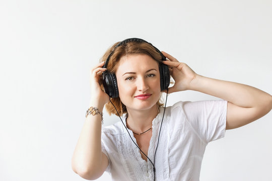 Beautiful girl with headphones listening to music and dancing in