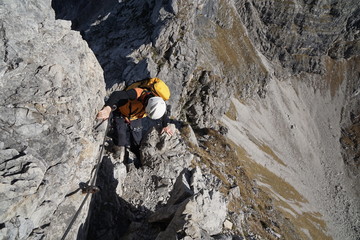 Bergsteiger am Klettersteig im steiler Felswand