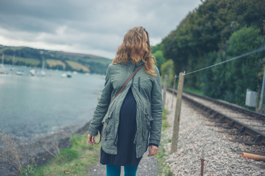Pregnant woman walking by river and railroad tracks