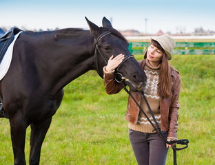 Woman and  horse, beige pullover, leather jacket, jeans, hat, cl