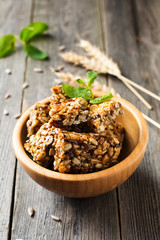 Roasted nuts and sunflower seeds in caramel and sugar in bamboo bowl on the old wooden background. Selective focus.