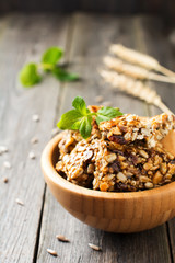Roasted nuts and sunflower seeds in caramel and sugar in bamboo bowl on the old wooden background. Selective focus.