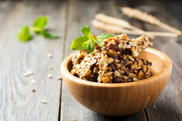 Roasted nuts and sunflower seeds in caramel and sugar in bamboo bowl on the old wooden background. Selective focus.