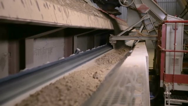 Conveyor with soil. Clay goes through transporter in a mining factory. HD.