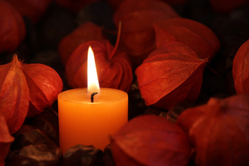 Kerze mit Lampionblumen und Kastanien