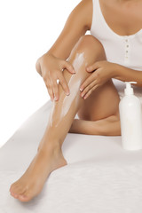 Obraz na płótnie Canvas Woman applying protective cream after waxing leg