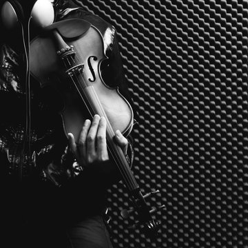 male musician playing violin in recording studio, black and white
