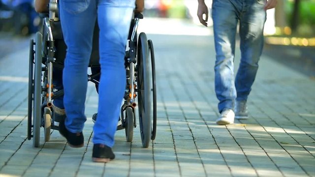The man walk with a disabled on the street. Slow motion