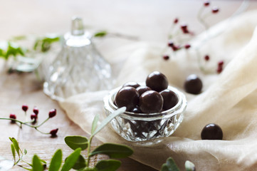 Closeup of chocolate dragee in a glass bowl. Fresh decor