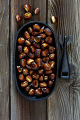 Roasted chestnuts on an old board. Selective focus.
