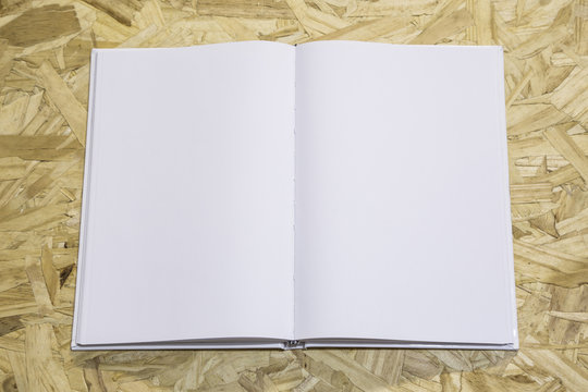 Real 3D hardcover white book opened on a recycled wood background