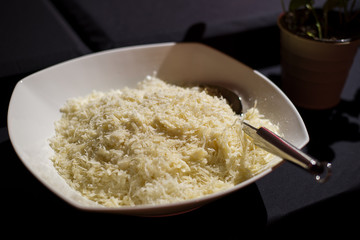 Geriebener Parmesan auf weissem Teller