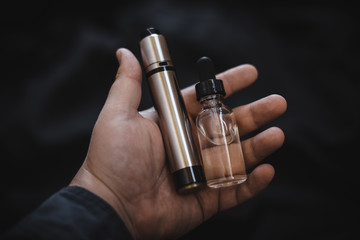 Vaping device in in the man's hand. Electronic cigarette, vape