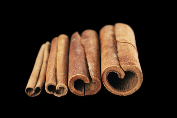 Cinnamon sticks isolated on black background.