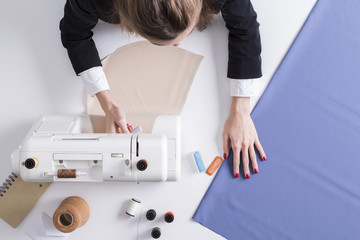 Woman using her sewing machine and touching material