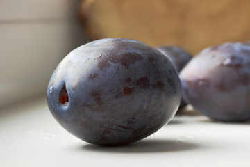 Plum is on a white sill.Close-up.