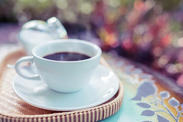 Obraz na płótnie Canvas Coffee cup on vintage table against bokeh background. Vintage color style.