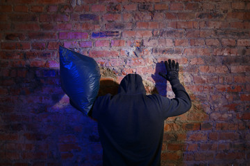 Bandit with bag near wall