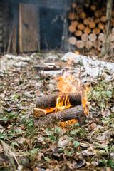Bonfire, fire. Rest in the woods on a halt. Hunting Lodge. Autumn, cold and cloudy weather, snow.
