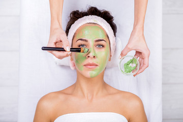 Young woman in a spa with algae facial mask. Woman in spa salon