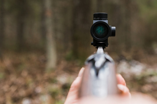 Hunting Rifle Sight, Close-up. Optical Sight. A Red Dot. A Man Holding A Gun.