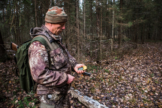 Man hunter with a gps navigator in the forest. Orienteering in the forest, a route map. Technology, Gadget.