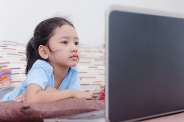Close up portrait shot of asian little girl using laptop compute