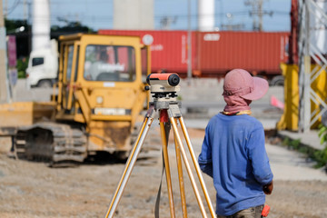 Fototapeta premium Surveyor equipment tacheometer or theodolite outdoors at construction road against worker blur background