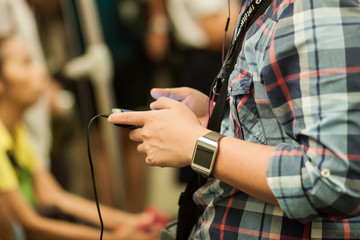 man's hand with smart watch holding smart phone in train