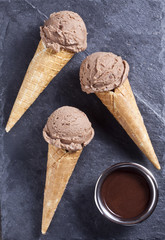 Chocolate ice cream cones on the stone surface.