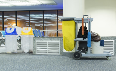 Yellow mop bucket and set of cleaning equipment in the airport