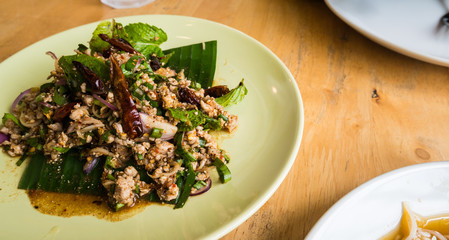 Spicy Minced Chicken Salad on wood table in restaurant.