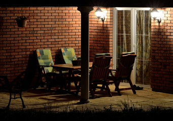 Modern house terrace (patio) with garden furniture at night